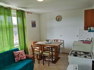 a kitchen with a table and a couch in a room at David in 5 in Primošten