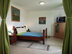 a bedroom with a bed and a television and curtains at David in 5 in Primošten