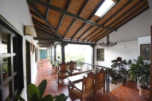 a living room with a wooden ceiling and a table and chairs at Hospederia La Fuente in Villa de Leyva