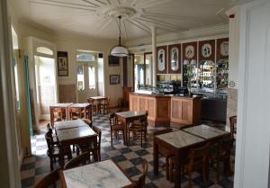 a restaurant with tables and chairs and a bar at Internacional Azores Boutique in Horta