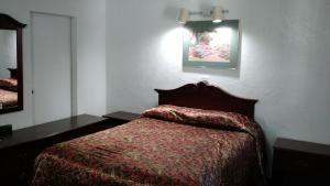 a bedroom with a bed and a picture on the wall at El Rancho Motel in Watsonville