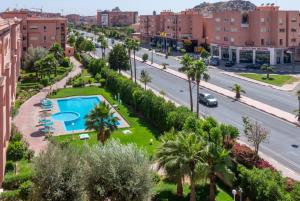 una calle de la ciudad con piscina y palmeras en Majorelle family residence en Marrakech