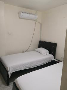a bed in a small room with a white bedvisor at Hospedaje el Parque in Soledad