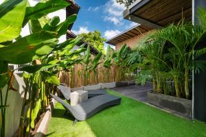a garden with a chair and some plants at Canggu Dream Studios & Villas in Canggu