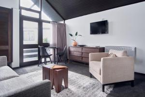 ein Wohnzimmer mit einem Sofa, Stühlen und einem Tisch in der Unterkunft Hotel Carlton Mill in Christchurch