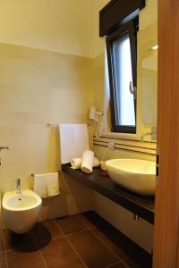 ein Badezimmer mit einem weißen Waschbecken und einem Spiegel in der Unterkunft Olo Kalò Locanda in Corigliano dʼOtranto