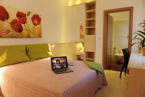 Olo Kalò Locanda في كوريليانو دوترانتو: غرفة نوم مع سرير مع لاب توب عليه +45 صورة