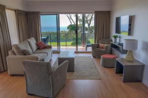 una sala de estar con muebles y vistas al océano. en Amooran Oceanside Apartments and Motel, en Narooma