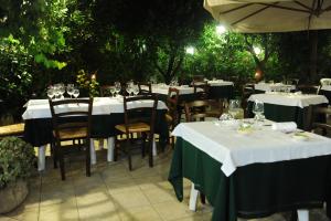 a restaurant with tables and chairs with wine glasses at Olo Kalò Locanda in Corigliano dʼOtranto