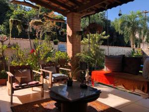 Un patio con un sofá y sillas y una mesa. en Refugio de Paz, en São Pedro