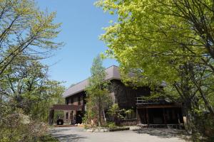 un edificio con árboles delante de él en ARtINn 極寒藝術伝染装置, en Teshikaga