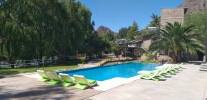 a swimming pool with lounge chairs and a swimming pool at Cabañas del Cerro in Valle Grande