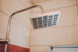 einen Duschkopf mit einem Thermometer im Bad in der Unterkunft Apartments Gjoce in Ohrid