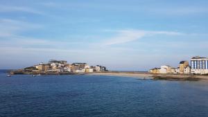 a view of a beach with houses and buildings at HOSTAL BODEGÓN A COSECHA in San Ciprián