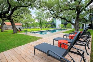 un gruppo di sedie e tavoli accanto a una piscina di The Ruby Hotel a Round Rock