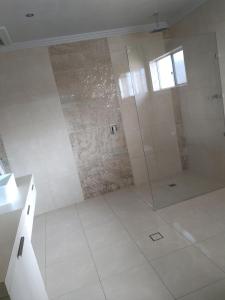 a bathroom with a shower with a glass door at Kindred Studio Apartments in Leeton