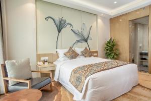 um quarto com uma grande cama branca e uma cadeira em Xi'an Peace Arch Hotel em Xian