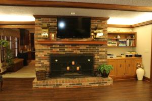 a brick fireplace with a tv on top of it at Cedar Grove Inn in Lebanon