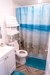 a bathroom with a toilet and a shower curtain at Lux 3 Bd - Perfect & Parking & Massive Patio in Ventnor City