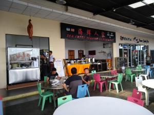 a group of people sitting at tables in a restaurant at Wave View Hotel in Semporna