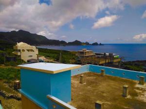 a blue building with a view of the ocean at Fu Ya N B&B in Lanyu