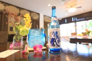 a bottle of wine sitting on a table with flowers at Kerama Terrace in Tokashiki