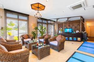 a living room with wicker chairs and a tv at Kerama Terrace in Tokashiki