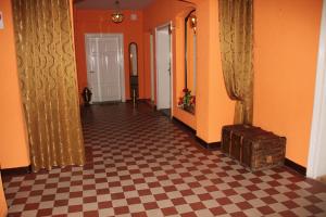 um corredor com paredes cor-de-laranja e um piso em xadrez em Willa Podzamcze em Zabkowice Ślaskie