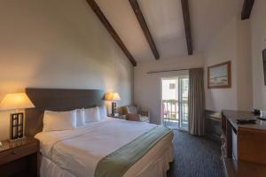 um quarto de hotel com uma cama grande e uma janela em Cannery Row Inn em Monterey