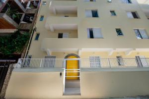 an apartment building with a yellow door and a balcony at Leblon Design Hotel in Rio de Janeiro