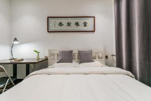 Un pat sau paturi într-o cameră la Ancient City Wall Home Apartment Xi'an