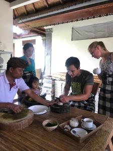 a group of people standing around a table at Arsa Wayan Guest House in Klungkung