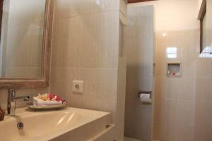 a bathroom with a sink and a mirror and a shower at Arsa Wayan Guest House in Klungkung +31 photos