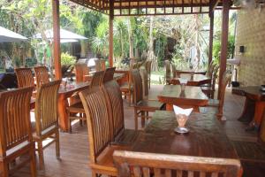 a restaurant with wooden tables and wooden chairs and tables at Nitya Home Stay Lembongan in Nusa Lembongan