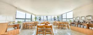 a restaurant with tables and chairs and large windows at Larosa Hotel Nha Trang in Nha Trang