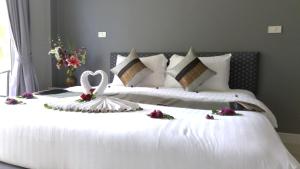 a bedroom with a white bed with a swan on it at MJ Boutique Hotel Khao Lak in Khao Lak