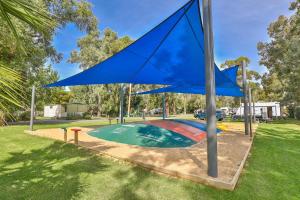 a blue flag in a park with a playground at Rivergardens Holiday Park Mildura in Gol Gol