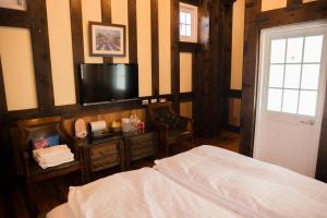 sypialnia z łóżkiem i telewizorem z płaskim ekranem w obiekcie Black Forest Manor w mieście Ren’ai