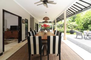 a dining room with a table and chairs at Villa Bloom 1 - 4 bedrooms, 4 bathrooms, private pool close to the beach in Seminyak