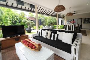 a living room with a couch and a tv at Villa Bloom 1 - 4 bedrooms, 4 bathrooms, private pool close to the beach in Seminyak