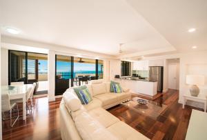a living room filled with furniture and a large window at Pinnacles Resort in Airlie Beach