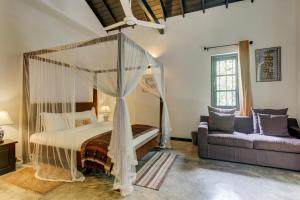 a bedroom with a canopy bed and a couch at Villa Republic Bandarawela (04 bedroom) in Bandarawela