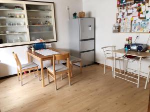 a kitchen with a table and chairs and a refrigerator at Guest House Ringo in Otaru