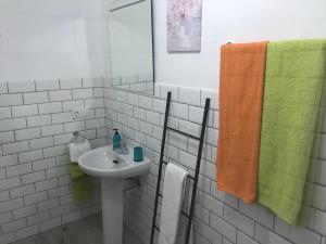 a bathroom with a sink and an orange and green towel at Maxorata City Center Fuerteventura in Morro del Jable +10 photos
