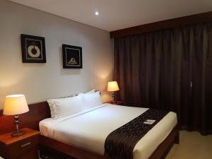 a hotel room with a bed and two lamps at PADDY'S HOTEL & APARTMENTS in Port Moresby