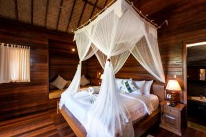 En eller flere senge i et værelse på Royal Cottage Nusa Lembongan