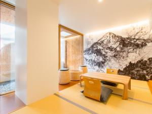 a room with a wooden table and a bench at TSUCHIYA Kinosaki onsen in Toyooka