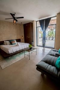 a large bedroom with a large bed and a couch at Hotel Bohonito Holbox in Holbox Island