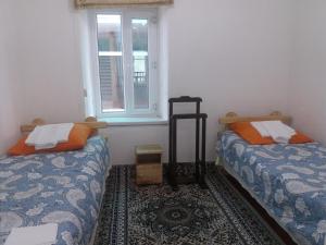 2 letti in una camera con finestra di Macedon Guest House a Barskoon