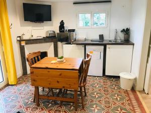 a small kitchen with a wooden table and chairs at Le Clos de la Gravette in Bessières